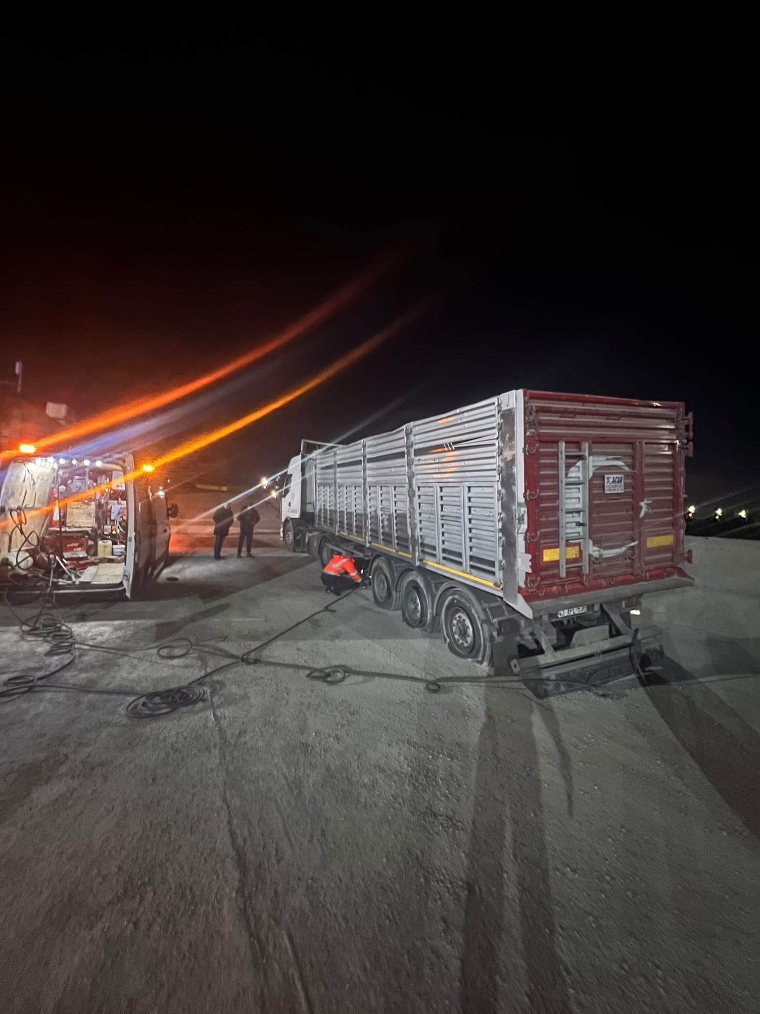 Gece mobil servis ekibinin tırın lastiği üzerinde çalışması